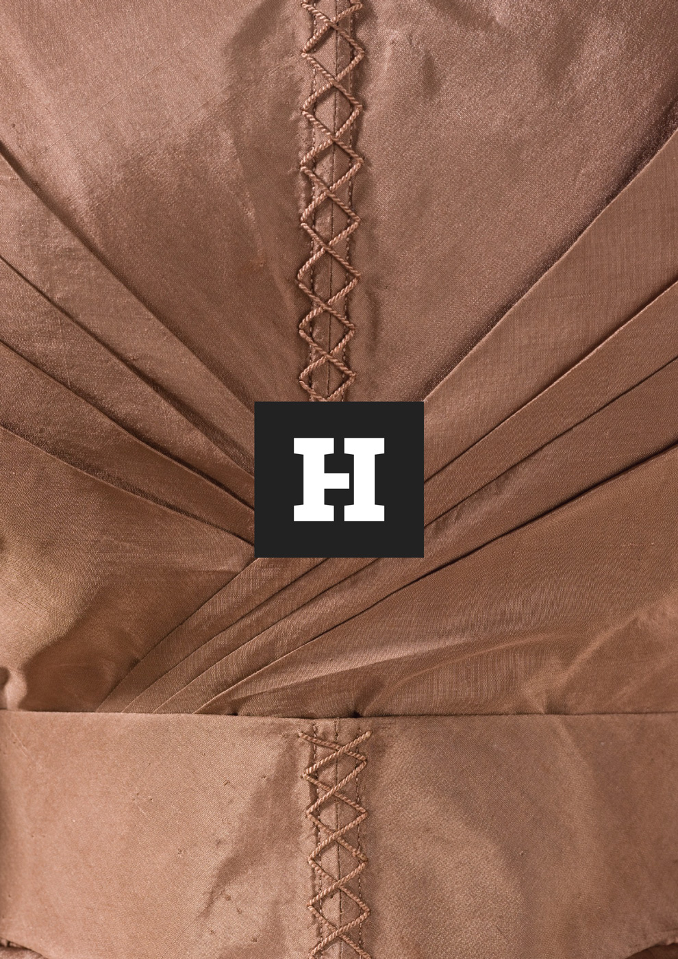 Aplicación de la marca sobre una fotografía profesional que muestra el detalle del tejido de un vestido de mujer histórico